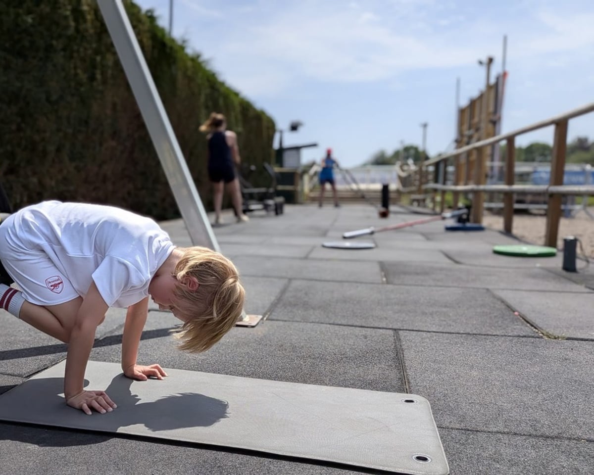 A junior training outdoors while adults train alongside