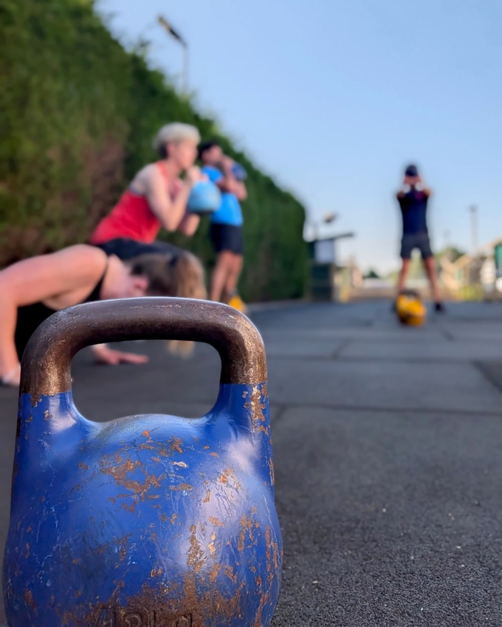 A small group training with kettlebells outdoors